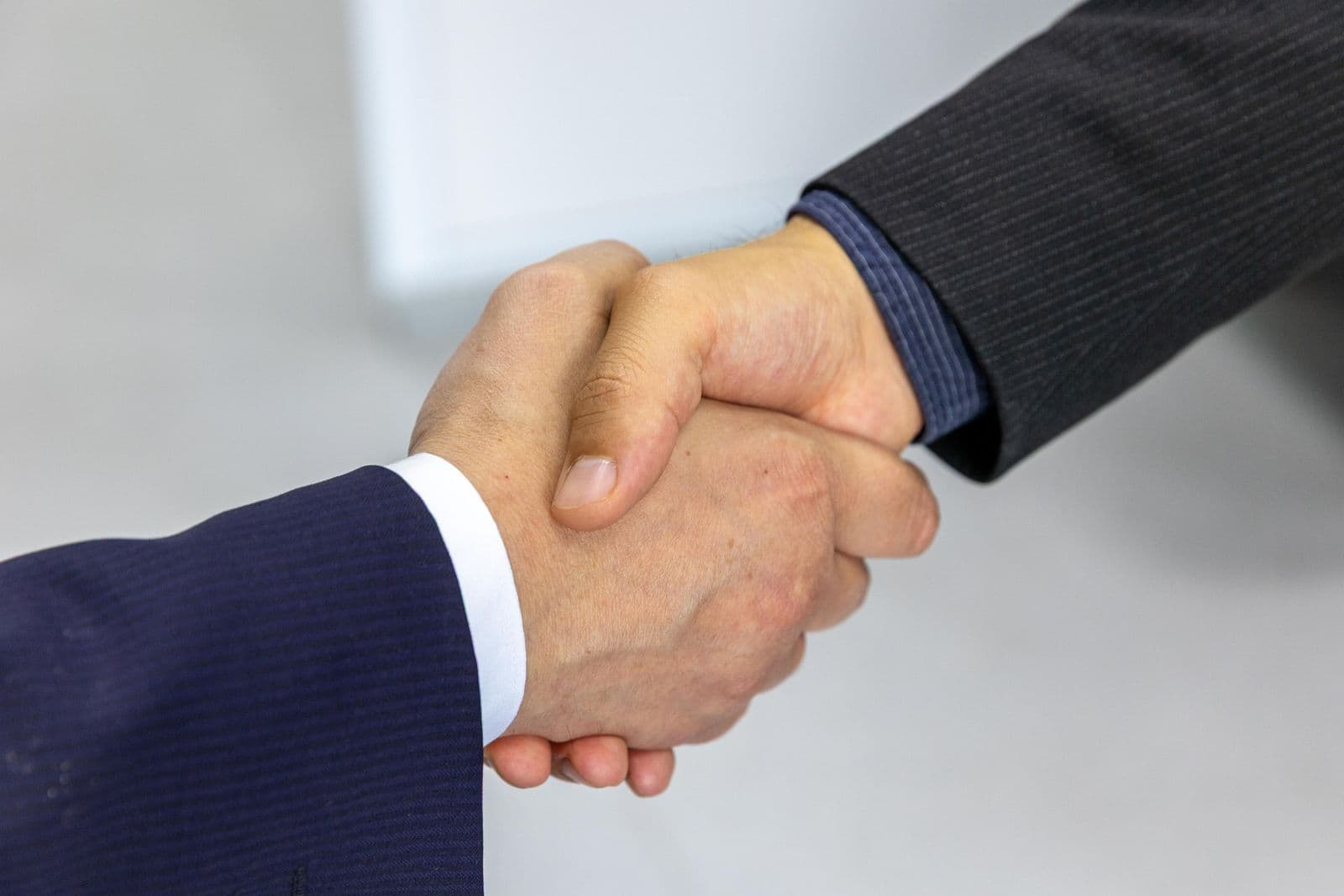 Two business professionals shaking hands to close an agreement in an office